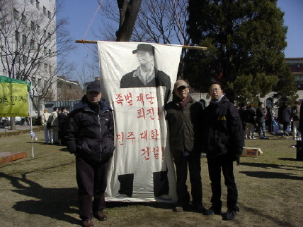 3월2일 입학식이 끝나고 도서관 앞에 세워진 천막농성장 앞에 세워진 걸개그림앞의 김동우교수, 황철민교수, 박춘노위원장 